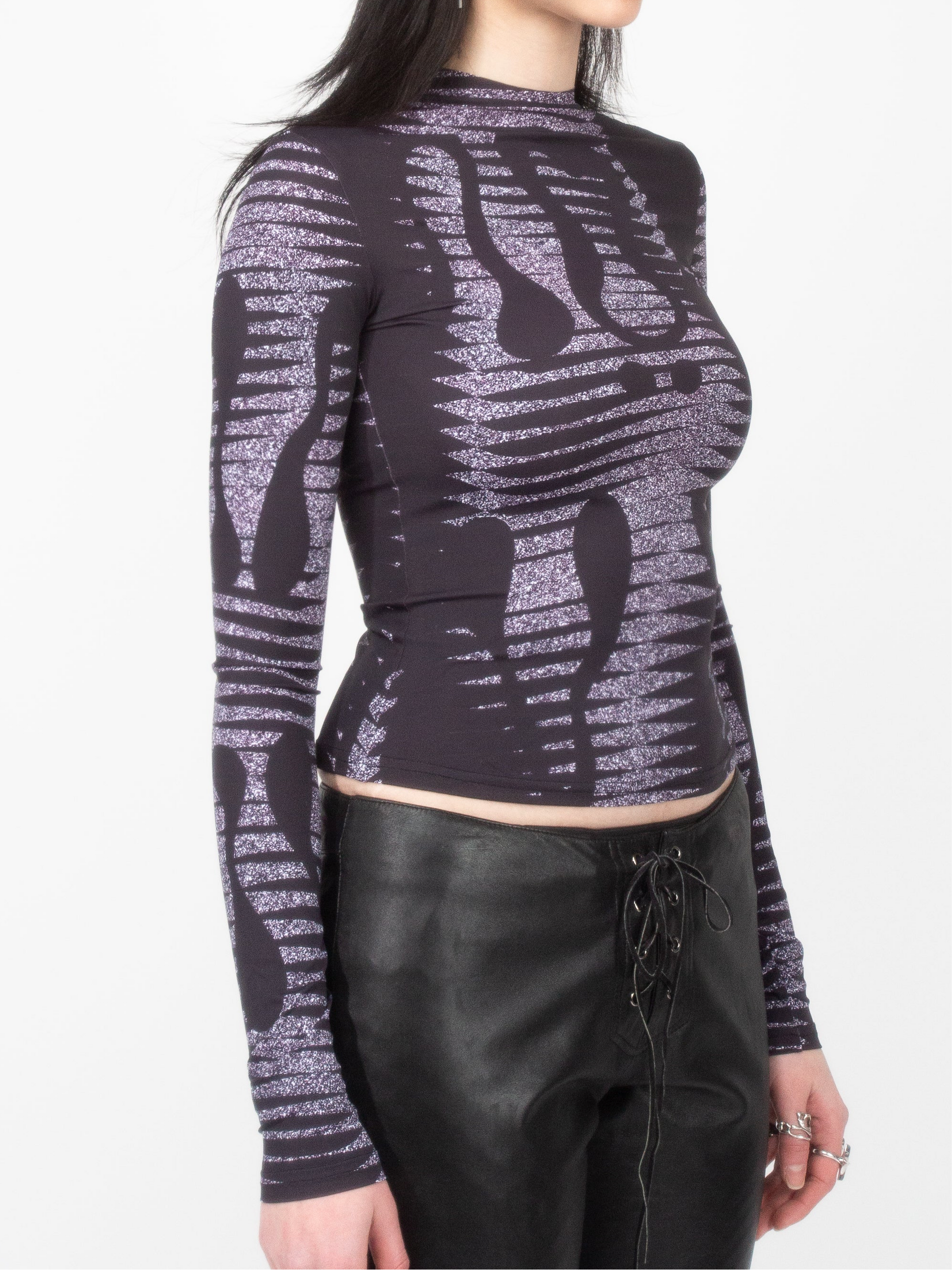 Side front view of female model model wearing VinöniV / VinoniV Noise fitted printed bodysuit jersey top in semi-purple color