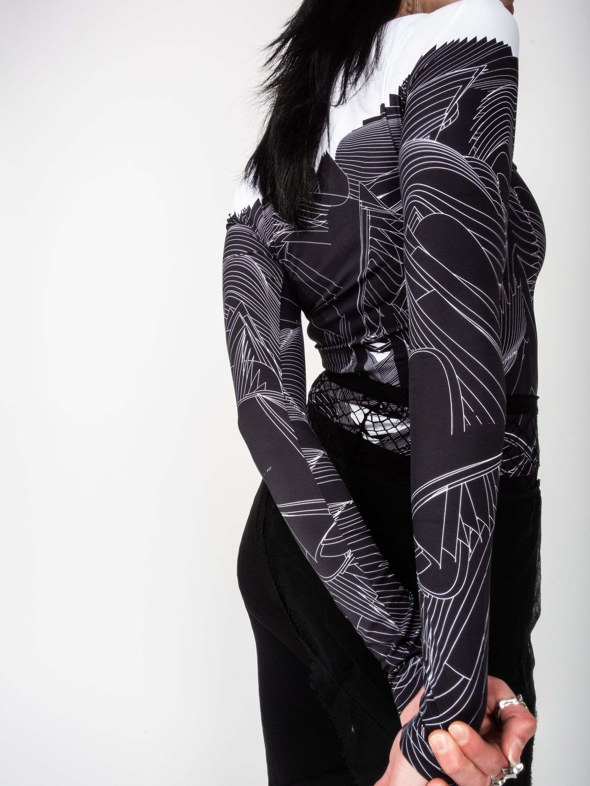 Close-up of side back view of male model wearing VinöniV / VinoniV Obsidian Feather Daydream jersey top bodysuit jersey top with soft feather-inspired black and white design.
