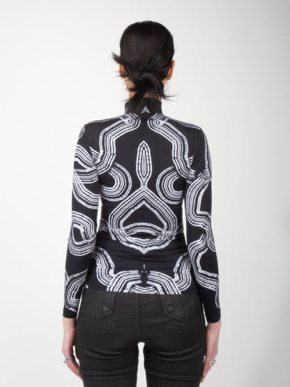 Back view of female model wearing Onyx Tide bodysuit jersey top black and white ocean print on jersey fabric by VinöniV / VinoniV featuring fluid, water-inspired design.